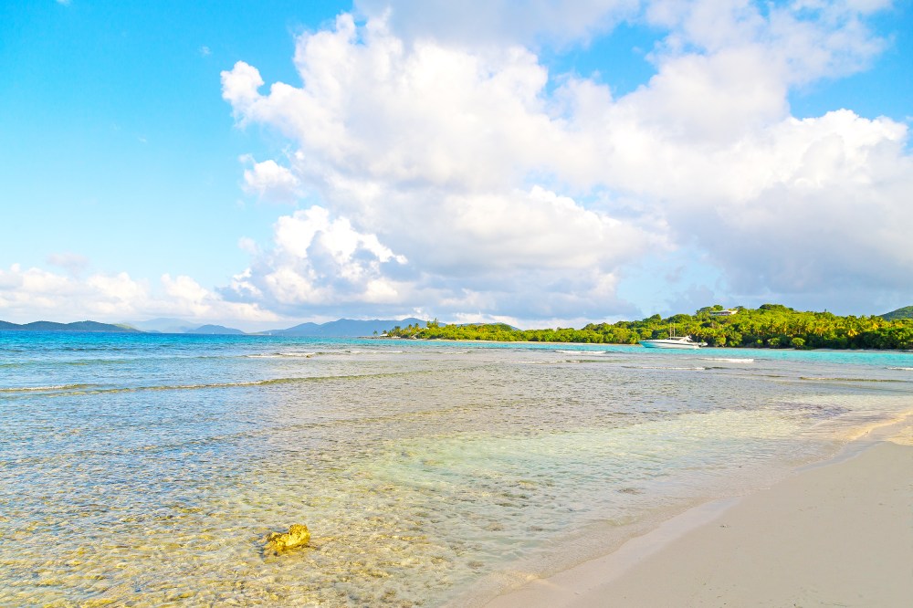 a sandy beach next to a body of water