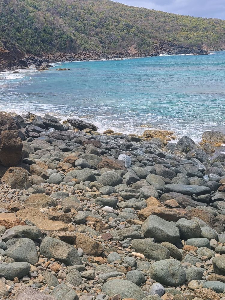 a rocky beach next to a body of water