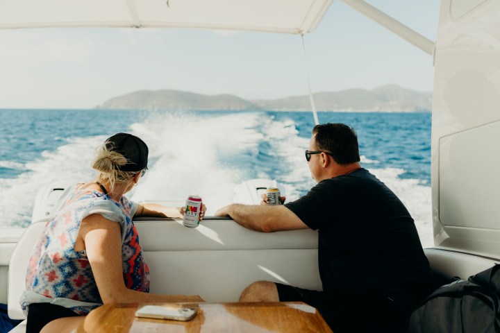 a man and a woman sitting on a boat in the water
